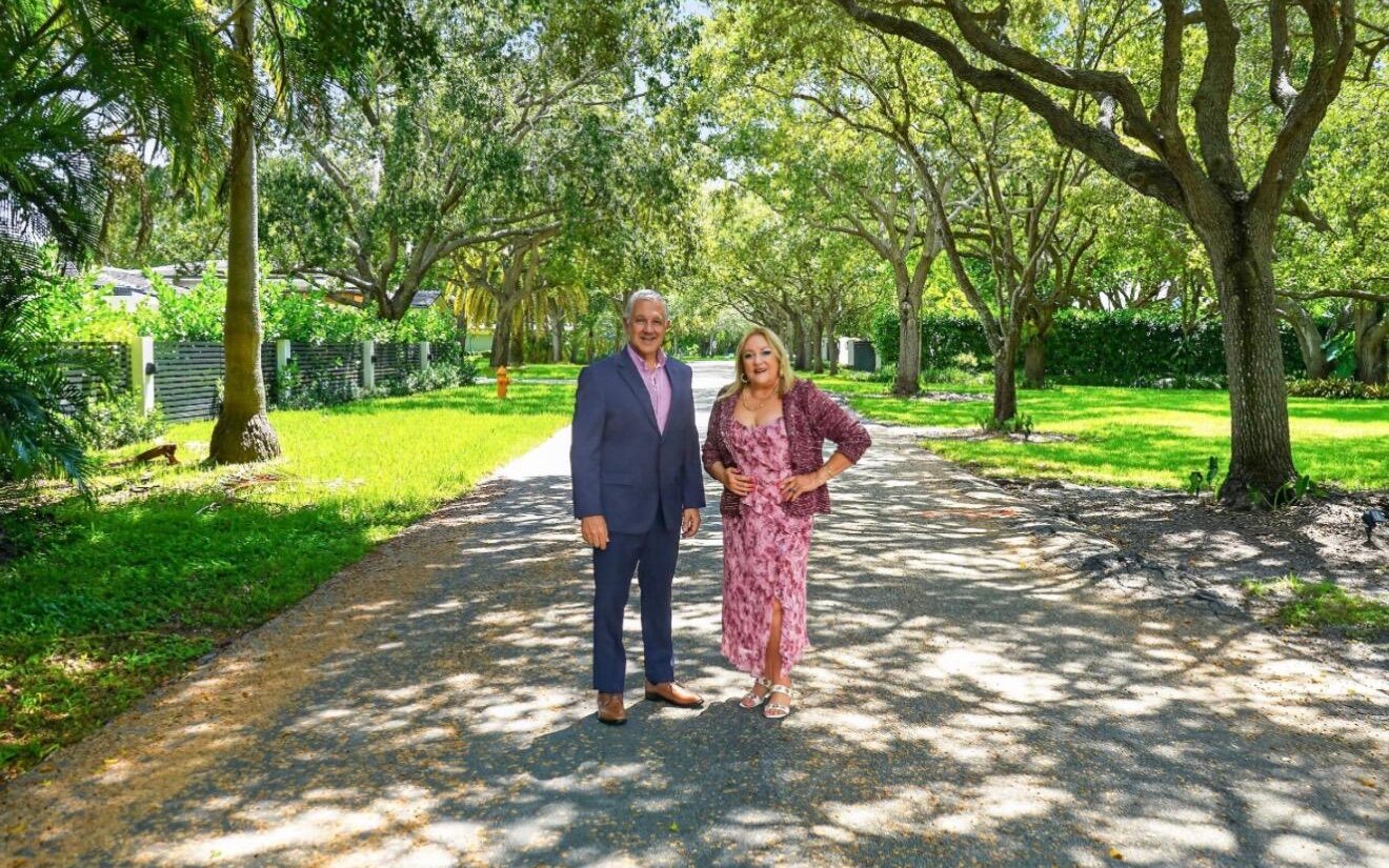 JC Malouf and Mimi Cairo of The Neighborhood Team on a tree-lined street in Palmetto Bay, Florida